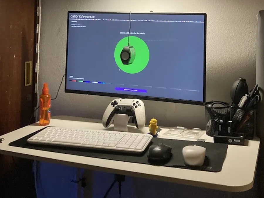 Kalibrasi monitor dengan sensor alat ukur di meja kerja klien